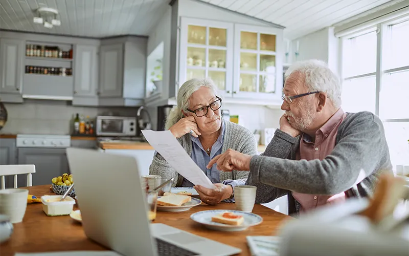 elderly couple paying bills