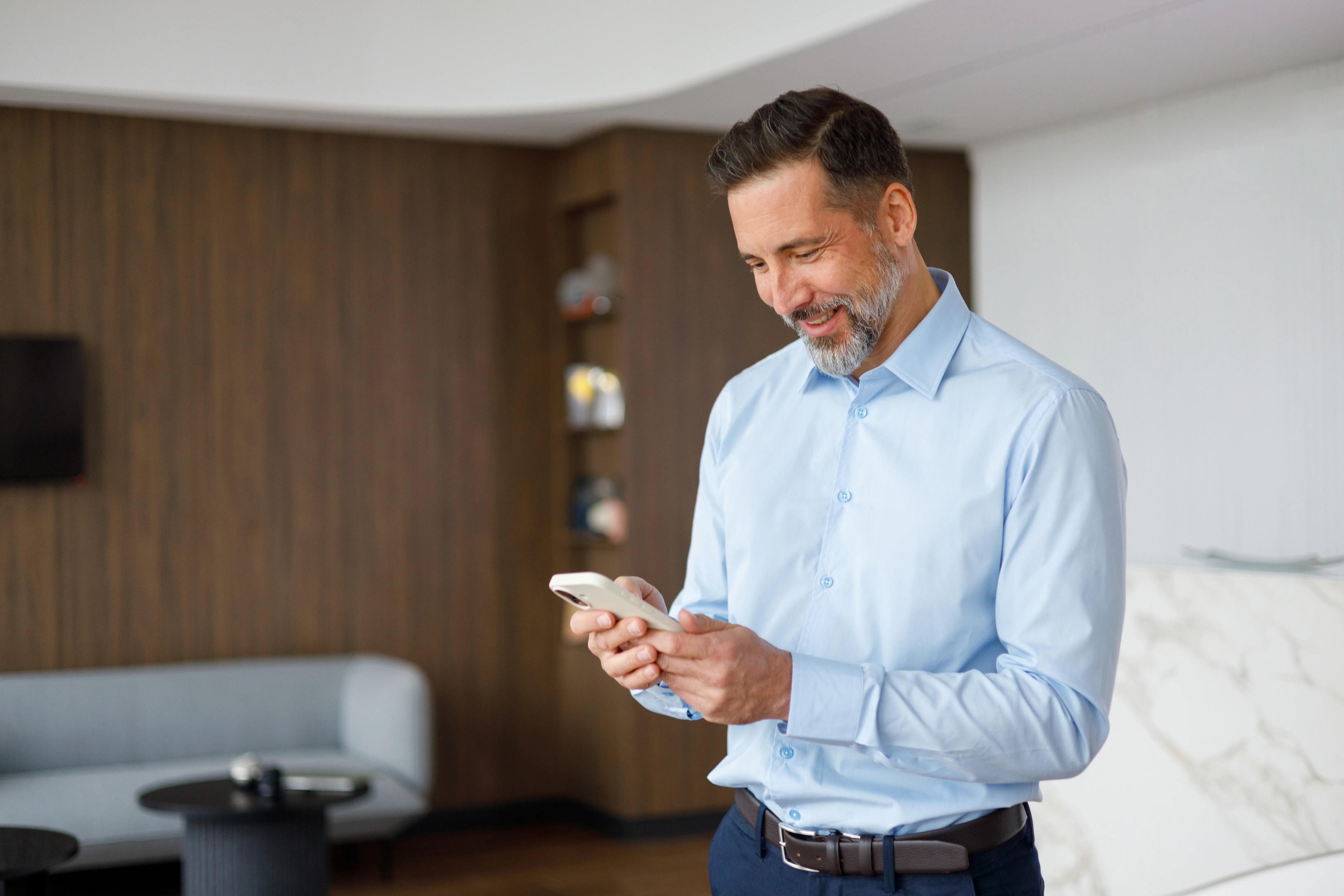 smiling businessman using smartphone to download the business app